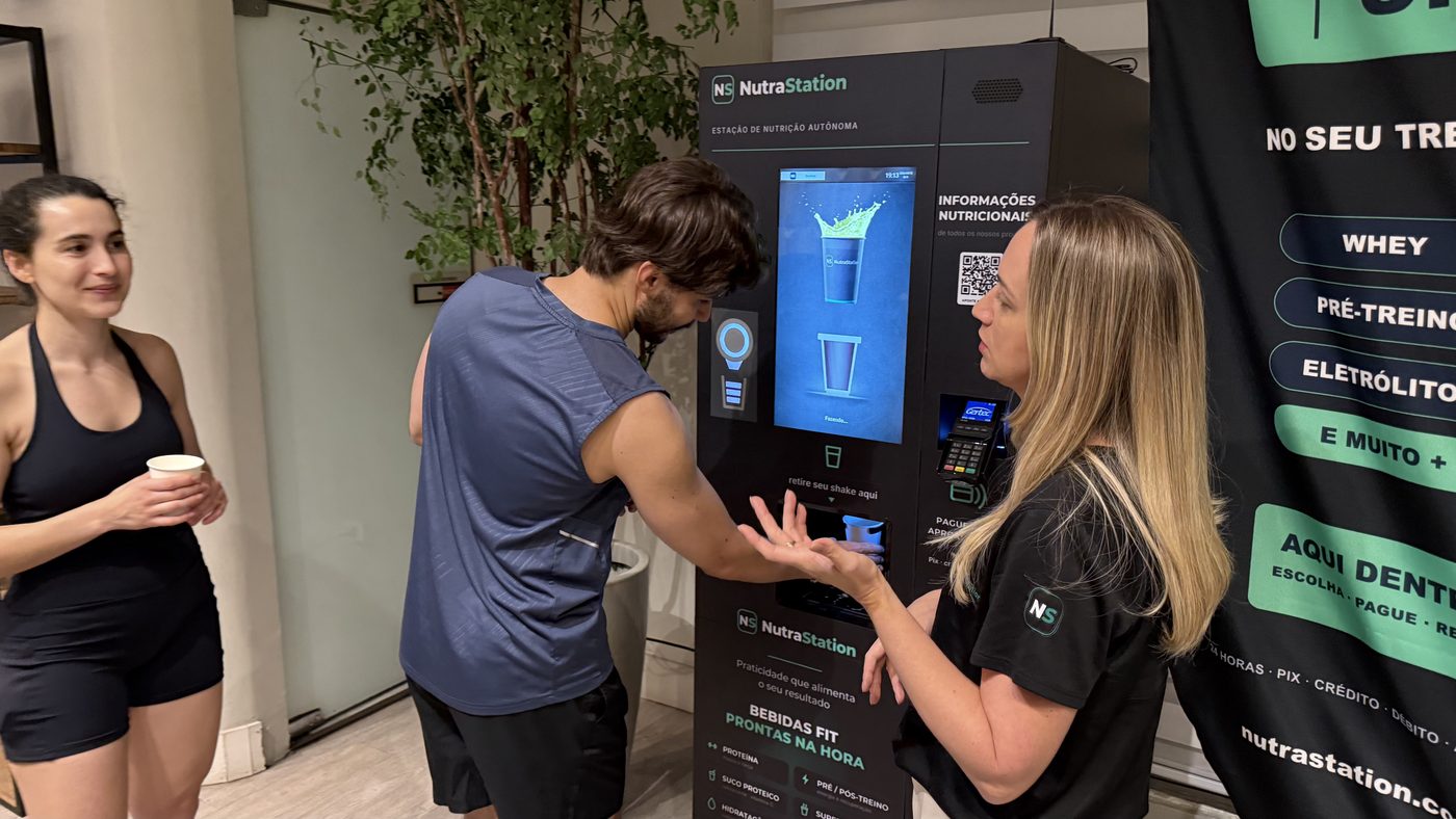 Equipe NutraStation apresentando a estação a dois frequentadores na inauguração da Body Shape